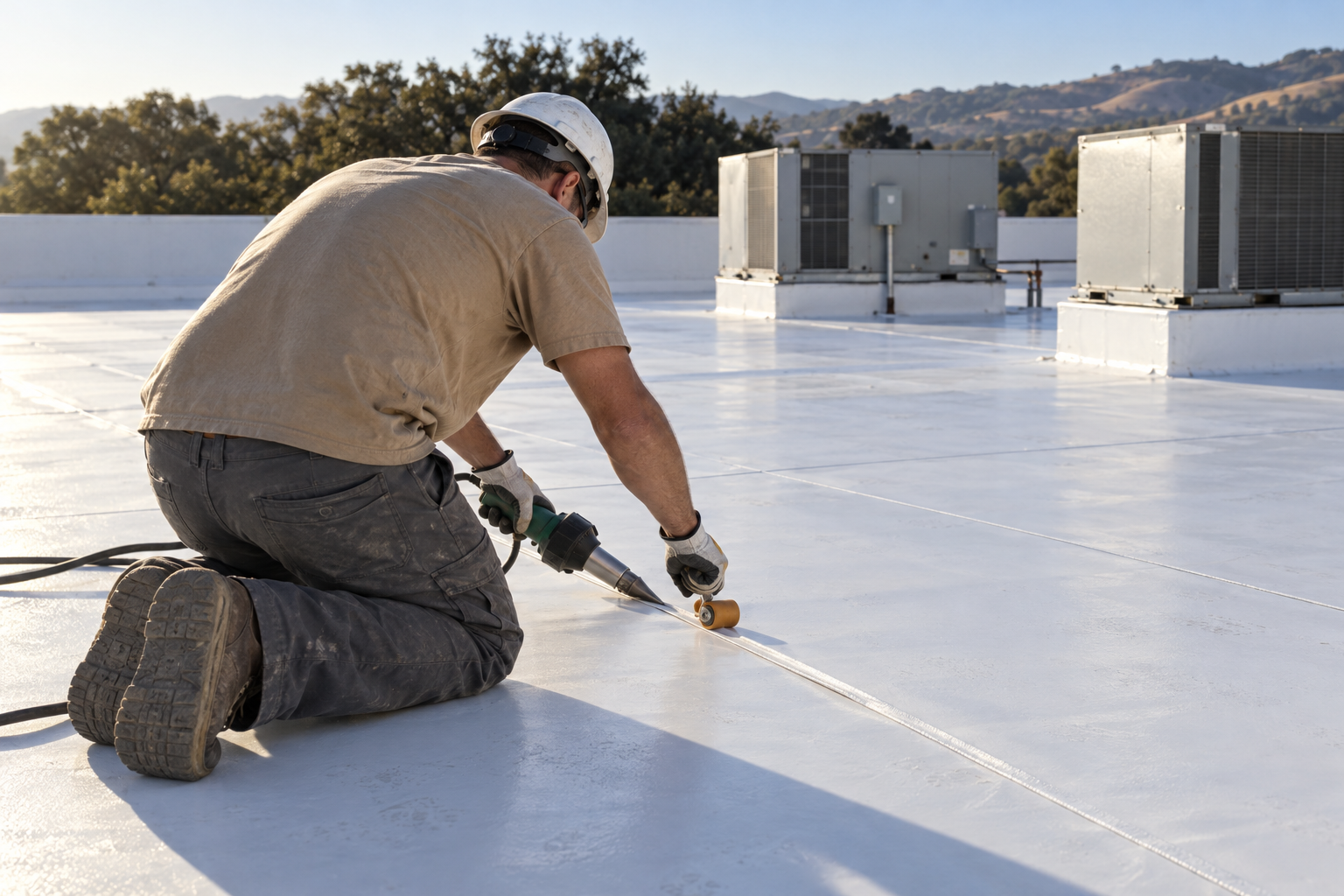 Roofer heat-welding a seam on a white membrane roof with rooftop air conditioning units behind